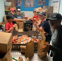 six people packing snack bags