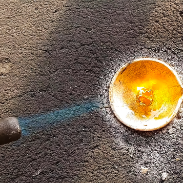 Glowing molten gold in a small crucible