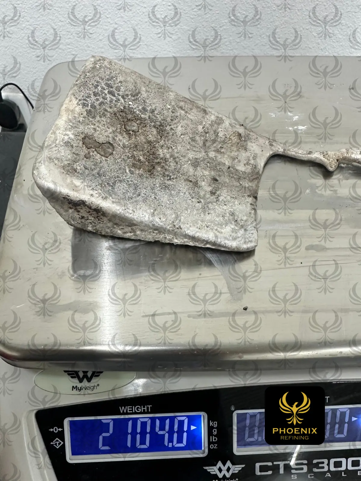 2,104 g silver doré bar on a scale